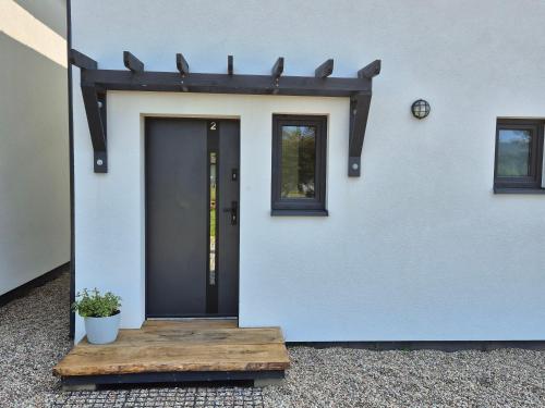 a door of a house with a potted plant at 9azaliowa - Domy całoroczne w Dębinie in Debina