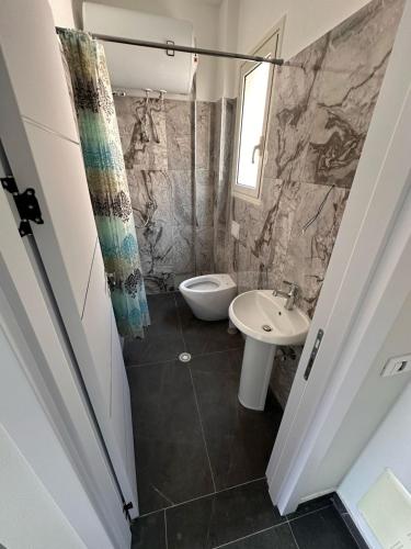 a bathroom with a toilet and a sink at TRIUMPH rooms and apartment in Vlorë