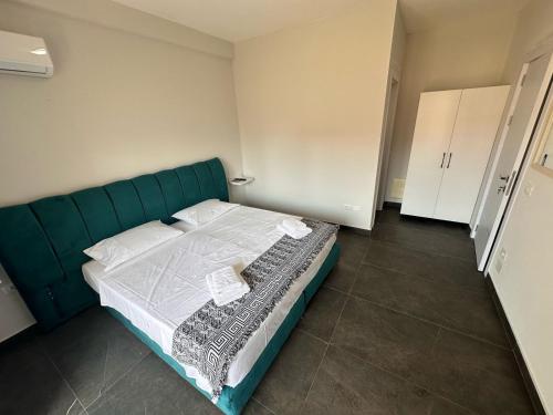 a bedroom with a green bed with white sheets at TRIUMPH rooms and apartment in Vlorë
