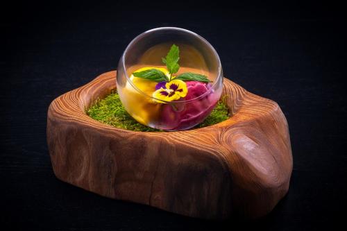 a glass bowl with a flower in it on a table at Hotel Golden Eagle in Levice