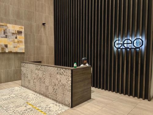 a man sitting at a reception desk in a building at Geo Bukit Rimau Condominium in Shah Alam