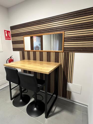 a wooden table with two chairs and a mirror at AMC Boente in Arzúa
