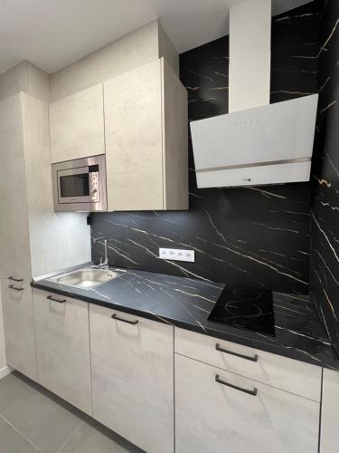 a kitchen with a sink and a microwave at AMC Boente in Arzúa