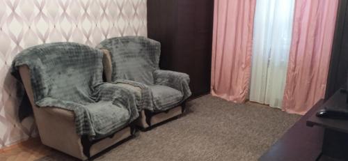Un par de sillas en una habitación con cortinas. en Квартира 2х-комнатная посуточно, en Krivoy Rog