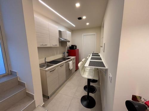 a small kitchen with a counter and a red refrigerator at Affittacamere Kalòs in Reggio Calabria