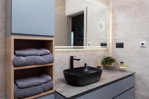 a bathroom with a black sink and towels at Beautiful Villa Scallop in Podlug