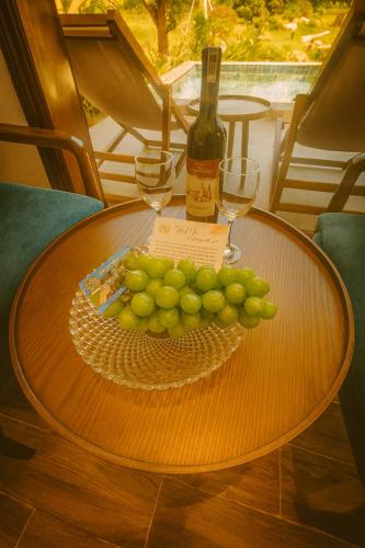 a table with a plate of grapes and a bottle of wine at Tam Coc Horizon Retreat in Vũ Lâm