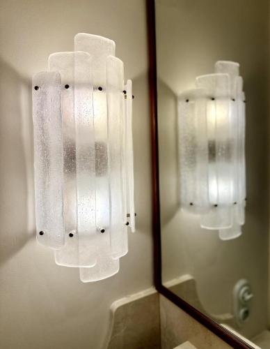 a bathroom mirror with white towels hanging on a wall at Hotel de Silhouette in Biarritz