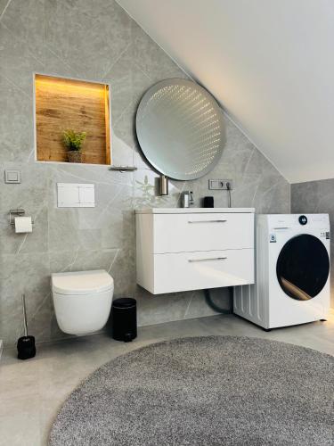 Un baño con lavabo, inodoro y espejo. en Whitewill by Gerda, 