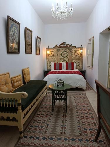 a bedroom with a bed and a couch and a table at El Patio Courtyard House in Tunis