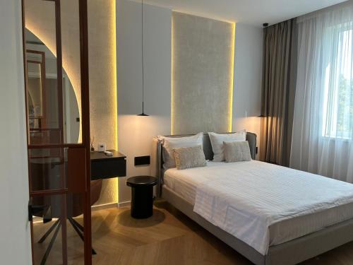 a bedroom with a white bed and a mirror at Premium Art Deco Loft in Iaşi