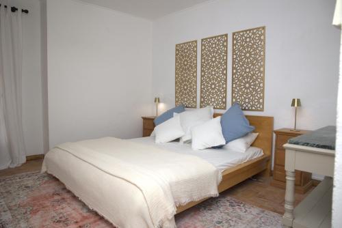 a bedroom with a bed with blue and white pillows at Pure Gardères in Monlezun