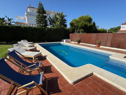 a swimming pool with lounge chairs and a swimming pool at Holiday house with private pool, Costa de la Luz in El Portil