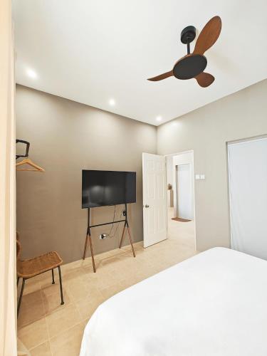 a bedroom with a bed and a flat screen tv at The Palm House in Dauis