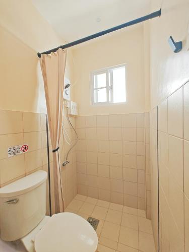 a bathroom with a toilet and a shower at The Palm House in Dauis