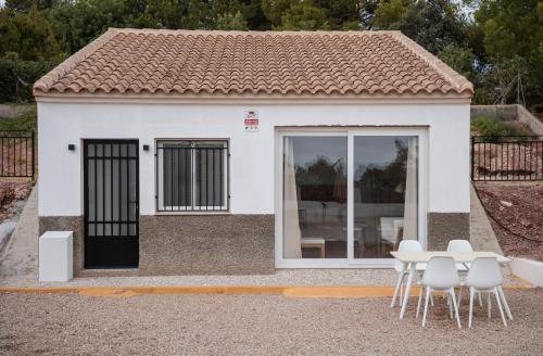 a small white house with a table and chairs at Apartment La casa Zamora in Totana