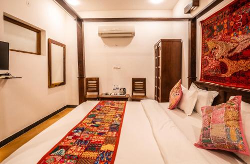 a bedroom with a bed with a colorful quilt on it at Tripli Hotels Surya Villas in Jaisalmer