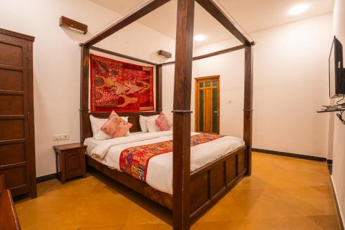 a bedroom with a canopy bed in a room at Tripli Hotels Surya Villas in Jaisalmer