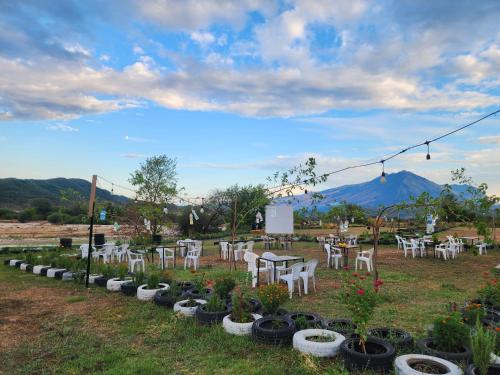 a row of tables and chairs in a yard with plants at Camping Shtepez in Gjirokastër