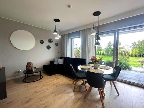 una sala de estar con un sofá y una mesa en APARTAMENTY Wakacyjna 53 Dziwnówek, Wrzosowo, en Dziwnówek