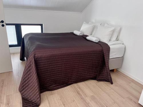 a bedroom with a bed with a brown blanket on it at Uusi, ilmastoitu ja valoisa 4 hlö huoneisto omalla sisäänkäynnillä in Joensuu