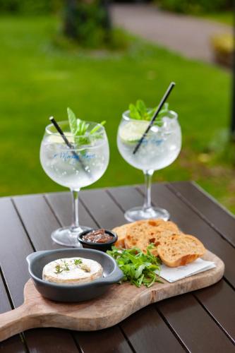 a table with three wine glasses and a plate of food at Morley Hayes Hotel in Derby