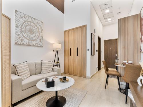 a living room with a couch and a table at Savis Homes - Luxury Brand New Studio in Elysee III in JVC in Dubai