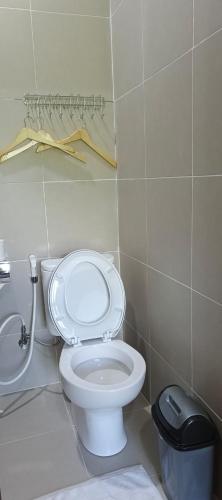 a bathroom with a white toilet and a trash can at Spring Hill Hotel Ruteng in Ruteng