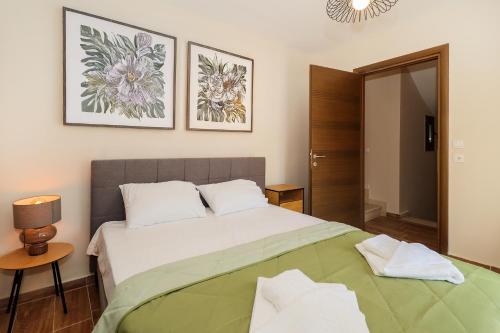 a bedroom with a large bed and two pictures on the wall at Villa Mykeli in Kriopigi