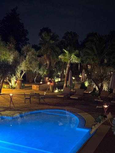 a swimming pool in a resort at night at Le mas de l'Ourika, maison d'hôtes in Aït Zat