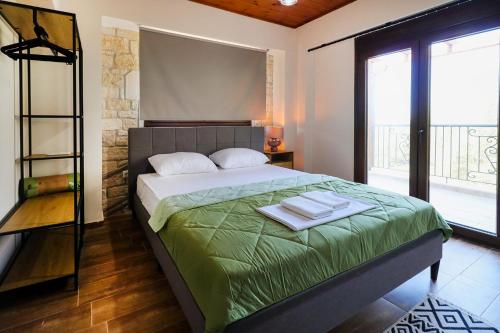 a bedroom with a bed with a green comforter at Villa Mykeli in Kriopigi