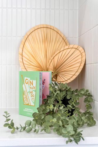 a shelf with two books and a potted plant at Canopy House Greenbank - Brand New Home in Natures Arms in Greenbank