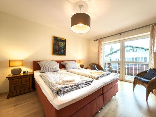 a bedroom with a bed and a large window at Alm Loge in Oberstaufen
