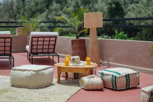 a patio with a table and two chairs and a lamp at Le mas de l'Ourika, maison d'hôtes in Aït Zat