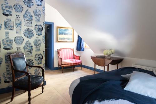 a bedroom with a bed and a chair at Château Marnand - Studio Vases Chinois in Granges-près-Marnand