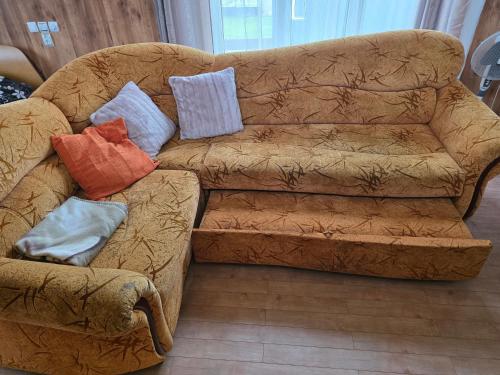 a brown couch with pillows on it in a living room at Family house in Dobele in Dobele