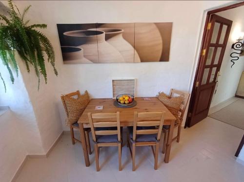 a dining room with a wooden table and chairs at Gästehaus Casa Roca Fataga in Fátaga