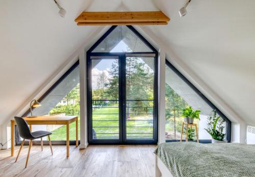 a room with a bed and a desk and a window at Bory Za Oknem in Tleń