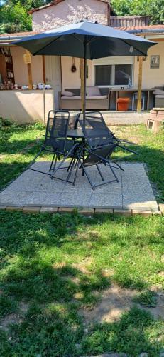a table and two chairs under an umbrella at Györgyök Háza in Eger