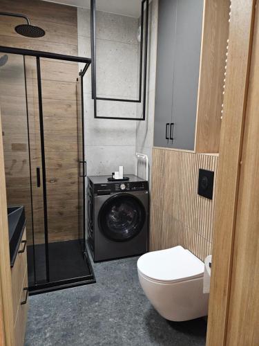 a bathroom with a washing machine and a toilet at AMapartments Sienkiewicza Residence - Ekskluzywny apartament w sercu Wrocławia z dostępem do tarasu na dachu in Wrocław