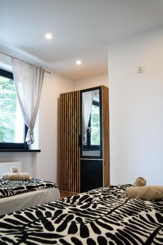 a bedroom with two beds and a mirror at Lipowa Apartamenty in Szczawno-Zdrój