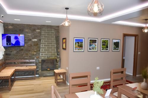 a living room with a fireplace and a tv on the wall at Vila Culli in Përmet