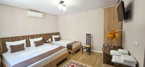 a hotel room with two beds and a television at Vila Culli in Përmet