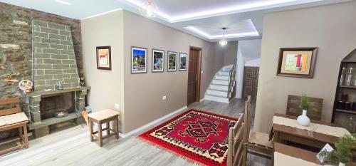 a living room with a fireplace and a red rug at Vila Culli in Përmet