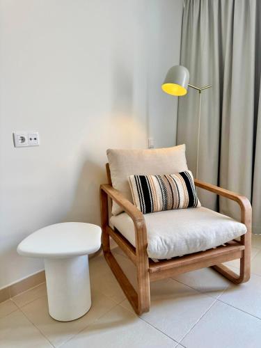 a chair and a table and a lamp in a room at Salgados Premium Beach Villa 4 Suites in Guia