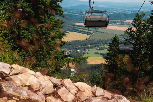 a gondola ride up a mountain with a view of a valley at Mlýnická Zahrada in Červená Voda