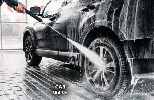 a person washing a car with a water hose at Wellness Hotel Step - Czech Leading Hotels in Prague