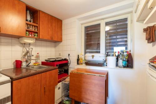 a small kitchen with wooden cabinets and a window at Kućica na brdu-Zaklopača in Zaklopača