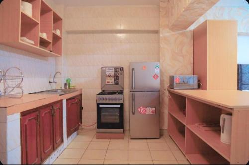 a kitchen with a refrigerator and a stove in it at Large Studio In Heart of Westlands in Nairobi