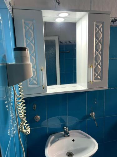 a blue bathroom with a sink and a mirror at Hostel la Bubu in Costinesti